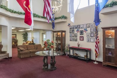 Interior view of a lobby area with sofas and flags