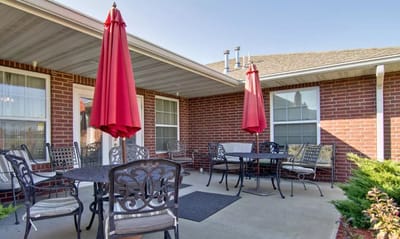 Outdoor patio area with tables and red umbrellas