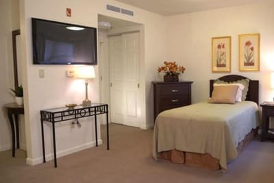 A cozy resident room with a bed and decorative elements