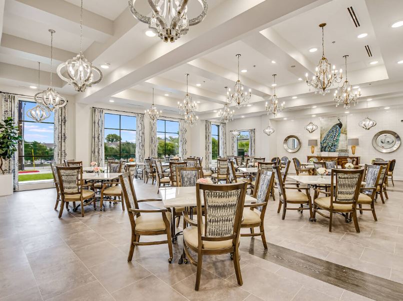 Elegant dining room with chandelier lighting and tables