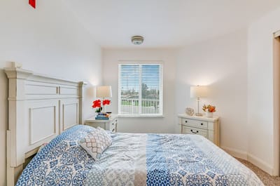 Bright resident room with a floral blanket and lamps
