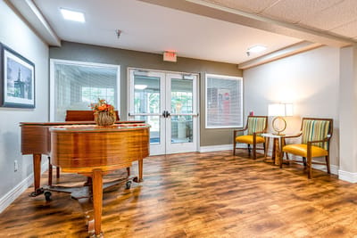 Bright common area with a grand piano and seating
