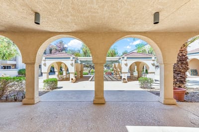 Covered outdoor area with arches and landscaping
