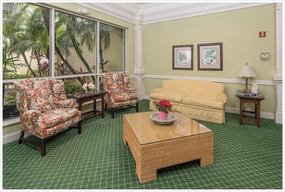 Bright common area with floral furniture and greenery