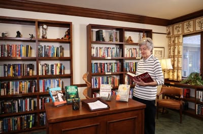 A resident reading in a well-stocked library