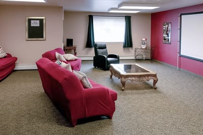 Cozy common area with red sofas and a coffee table