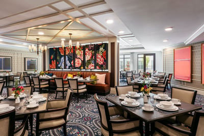 Brightly decorated dining room with floral artwork