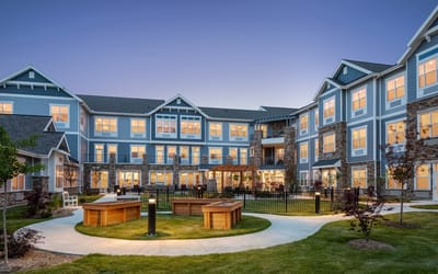 Exterior view of StoryPoint Northville at dusk with landscaped garden