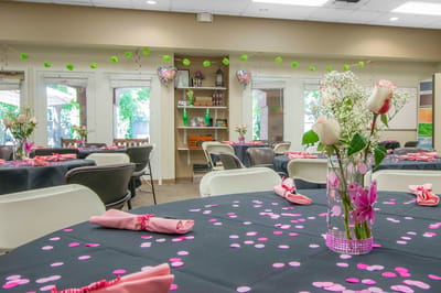Decorated activity room with tables and flowers