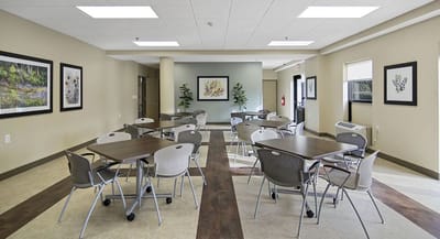 Bright common area with tables and chairs set up