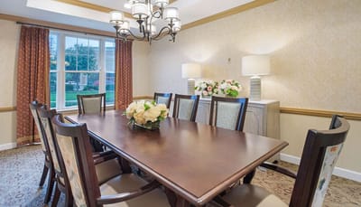 Bright common area with a large dining table and flowers