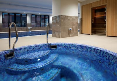 A modern indoor hot tub area with blue tiles