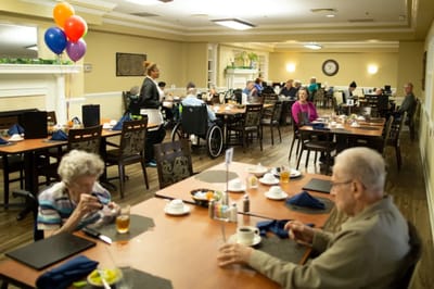 Residents enjoying meals in a dining room setup