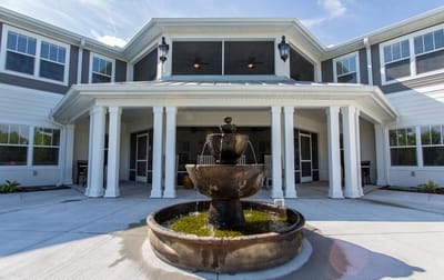 Front entrance of a senior living facility with a fountain