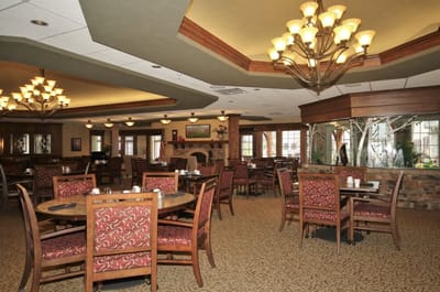 Dining area with tables and chairs in a senior living facility