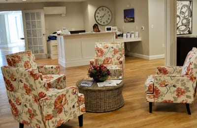 Bright common area with floral chairs and reception