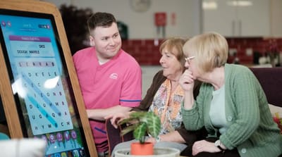 Residents engaging with a staff member during an activity