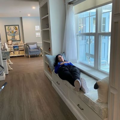 Resident relaxing on a bench by a window