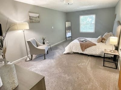 A well-furnished resident room with a bed and chair