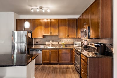 Modern kitchen area with appliances and wooden cabinets