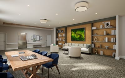 Bright common area with seating and a game table