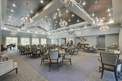 Elegant dining room with chandelier lighting and tables