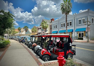 Outdoor view of a street with golf carts in front of buildings