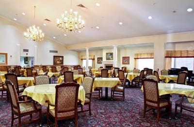 Dining area with yellow tablecloths and chandeliers