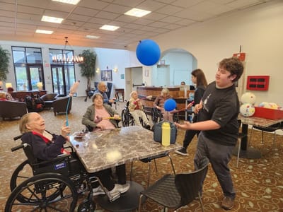 Residents engaging in a balloon activity in a common area