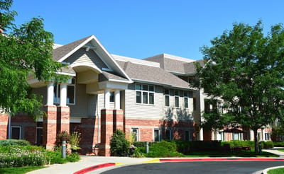 Exterior view of a senior living facility surrounded by greenery