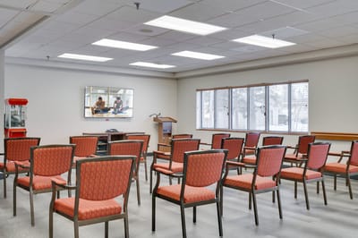 Common area with empty chairs and a small stage
