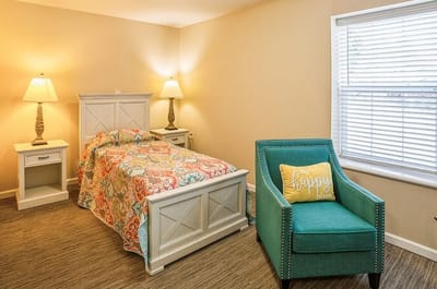 Cozy resident room with colorful bedding and chair