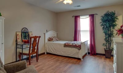 Cozy private resident room with a bed and chair