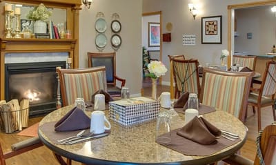 Cozy dining area with a fireplace and elegantly set table.