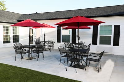 Outdoor patio with red umbrellas and seating