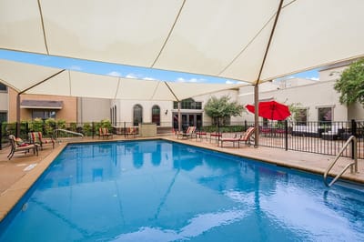 Outdoor swimming pool area with lounge chairs and umbrellas