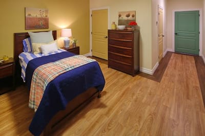 Cozy resident room with a bed and dresser