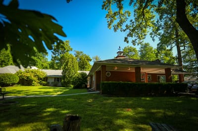 Exterior view of the assisted living facility surrounded by greenery