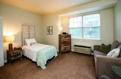 A cozy resident room with a bed and seating area
