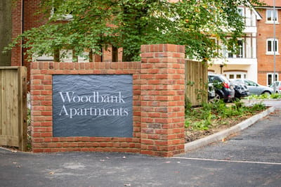 Sign for Woodbank Apartments at the entrance