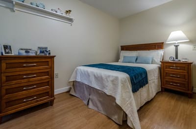 Cozy resident room with a bed and wooden furniture