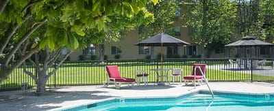 Outdoor pool area with seating and umbrellas