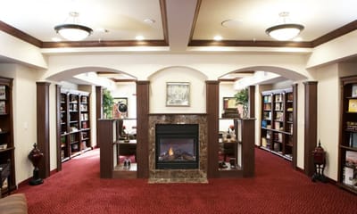 Interior view of a library with bookshelves and a fireplace