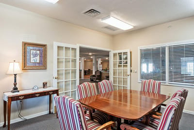 Bright dining area with wooden table and striped chairs