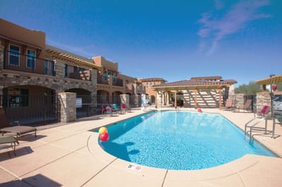 Outdoor pool area with lounge chairs and umbrellas