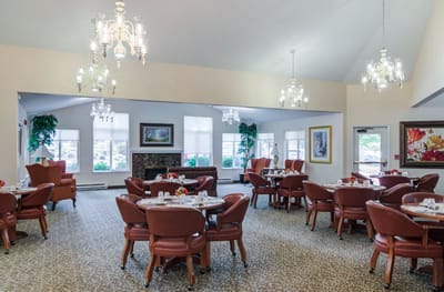Bright dining room with round tables and chandeliers