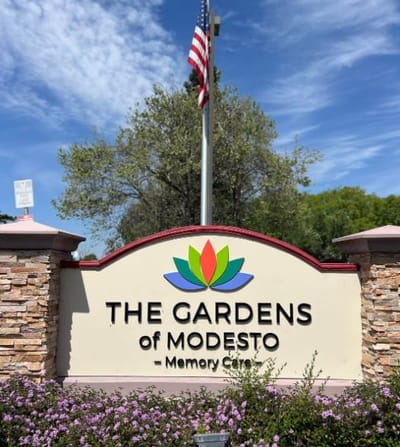 Entrance sign for The Gardens of Modesto with garden landscape