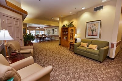 Common area with seating and dining space in a senior living facility