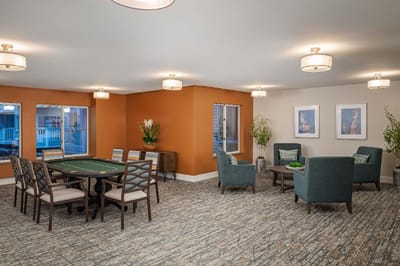 Bright common area with seating and a game table