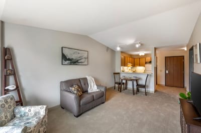 Bright interior of a senior living apartment with a living room and kitchenette